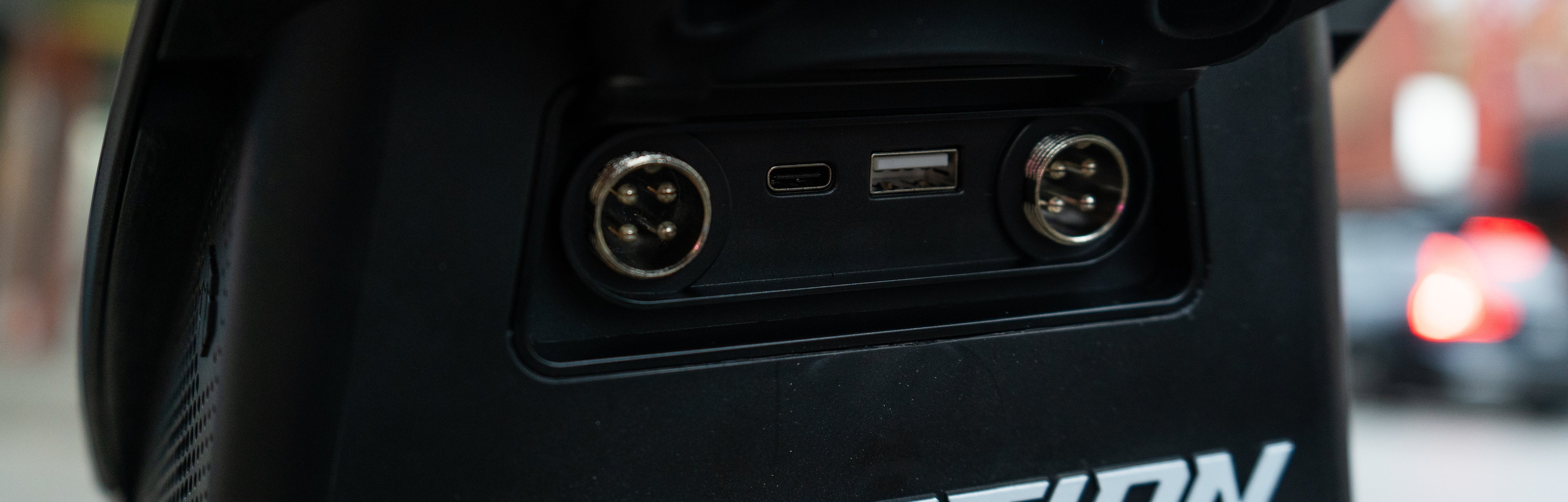 Close-up of InMotion V12S with 'INMOTION' branding, showing ports and connectors