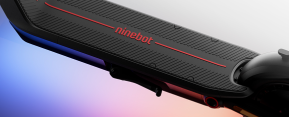 Close-up of electric scooter with 'ninebot' branding and a red light on a gradient background.