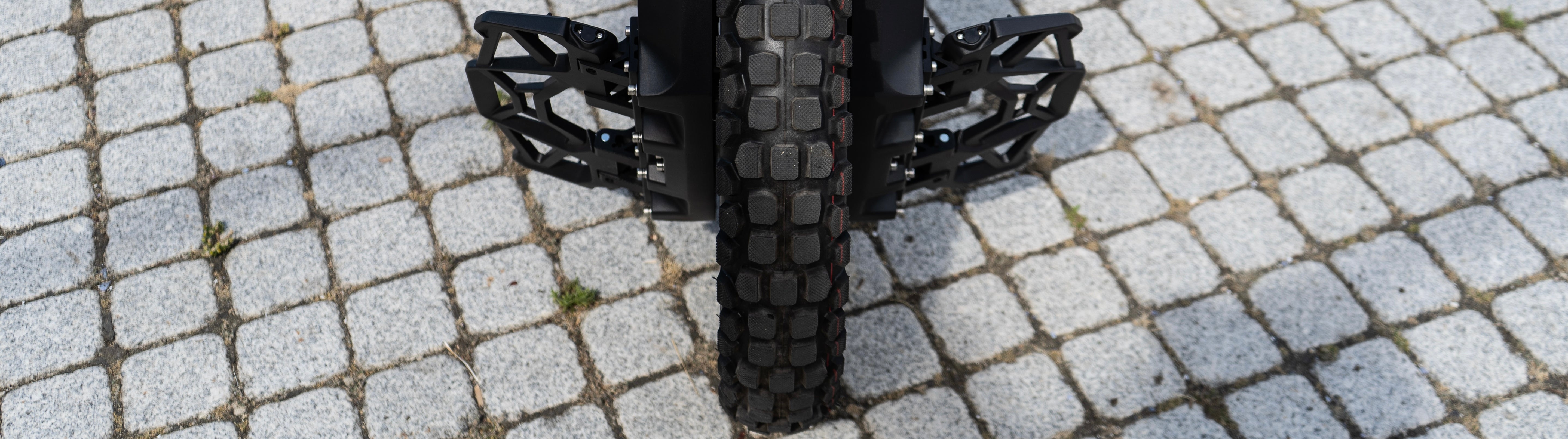 Close-up of a Veteran Oryx electric unicycle tire on a cobblestone surface